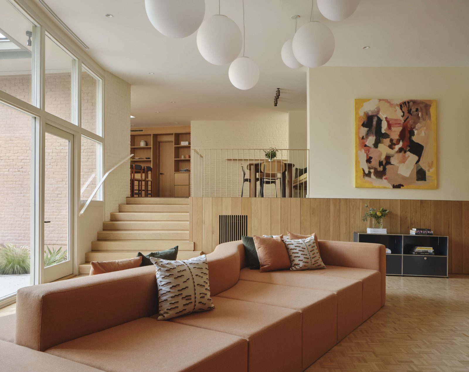 An era-bridging sunken living room provides a natural gathering place for more social occasions, with multiple orientations for conversation.