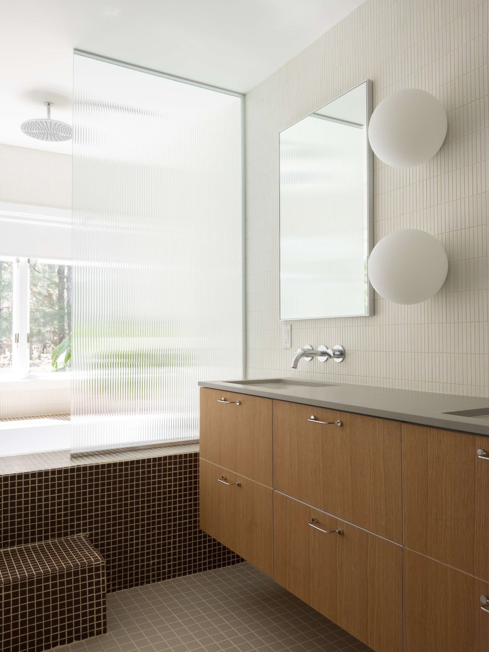 Tactile tile and ribbed glass define a bathroom with a step-in tub.