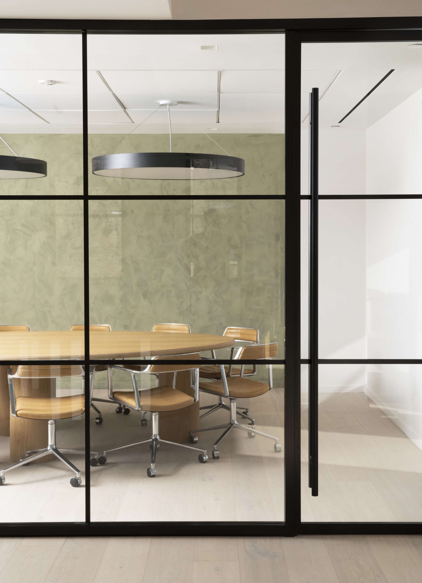 Textured limewash contrasts with slick, contemporary furnishings in a conference room.